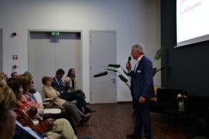 Luc De Bruyckere spreekt voor het publiek op de algemene vergadering van TAJO vzw.